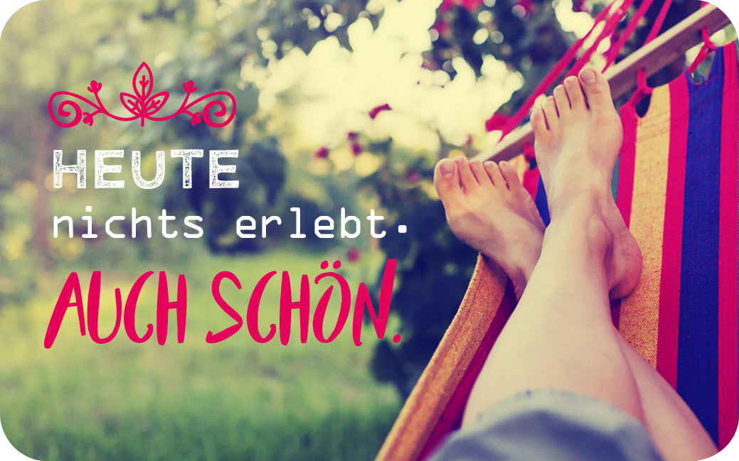 Gezeigt wird eine Innen- oder Zusatzansicht von „Einatmen, Ausatmen, Lächeln“. Die Bildkomposition vermittelt Entspannung, mit einem Fokus auf zwei Füße, die in einer Hängematte liegen. Die Schriftzüge „HEUTE nichts erlebt.“ in kräftigem Weiß und „AUCH SCHÖN!“ in warmem Rot heben sich kontrastreich vom sanften, natürlichen Hintergrund ab, der von grünem Gras und unscharfen Bäumen geprägt ist. Decorative Elemente in Form von floralen Mustern umrahmen den Text.