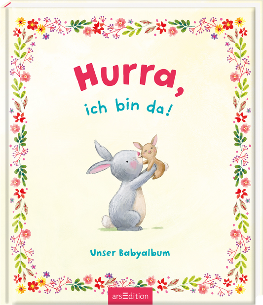 Das Cover zeigt einen fröhlichen, grauen Hasen, der ein kleines, braunes Kaninchen in die Luft hält. Der Hintergrund ist sanft in Cremefarben gehalten und von einem bunten Blumenstrauß eingerahmt. Der Titel „Hurra, ich bin da!“ ist in großen, geschwungenen, roten und blauen Buchstaben oben mittig platziert. Darunter steht in kleinerer Schrift „Unser Babyalbum“. Ganz unten mittig steht der Logoschriftzug von arsEdition.