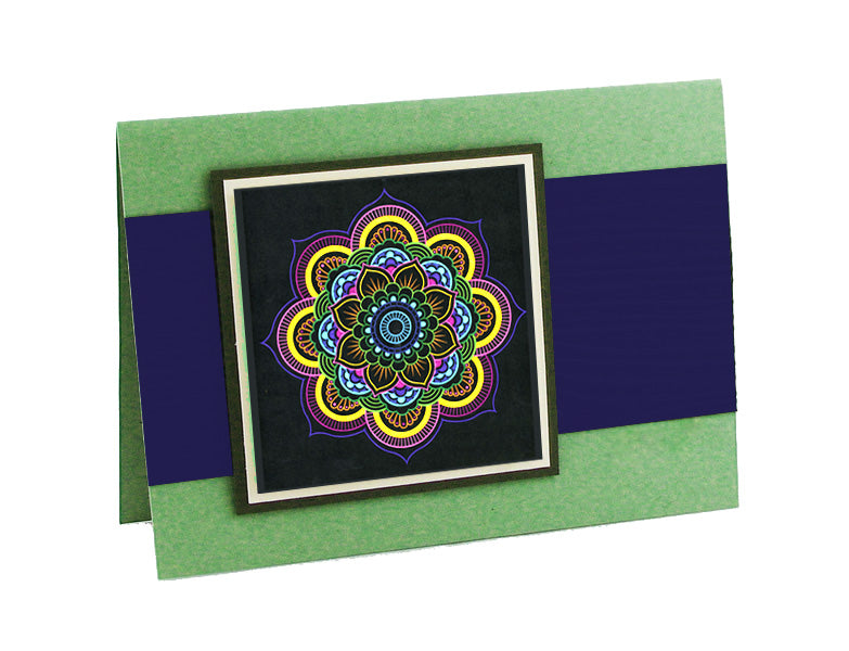 Gezeigt wird eine Innen- oder Zusatzansicht von „Mandala-Zauber“. Die Ansicht zeigt eine grüne Karte, die waagerecht aufgestellt wurde, mit einem tiefblauen Streifen. In der Mitte befindet sich ein buntes Mandala, das durch eine schwarze Hintergrundfarbe hervorgehoben wird. Die filigranen, geometrischen Muster in lebendigen Farben wie Gelb, Blau und Lila strahlen eine harmonische Ästhetik aus.