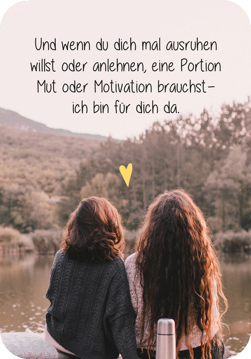 Gezeigt wird eine Innen- oder Zusatzansicht von „Für eine tolle Frau wie dich“. Der Hintergrund zeigt eine ruhige Wasseroberfläche und sanfte Hügel, umrahmt von Bäumen. Im Vordergrund sind zwei Personen Rücken an Rücken zu sehen, eine mit lockigem, braunem Haar und die andere mit schulterlangem, glattem Haar. Der Text in verspielter, handschriftlicher Schriftart vermittelt eine einladende Botschaft über Unterstützung und Nähe. Ein kleines, gelbes Herz ergänzt die Aussage und...