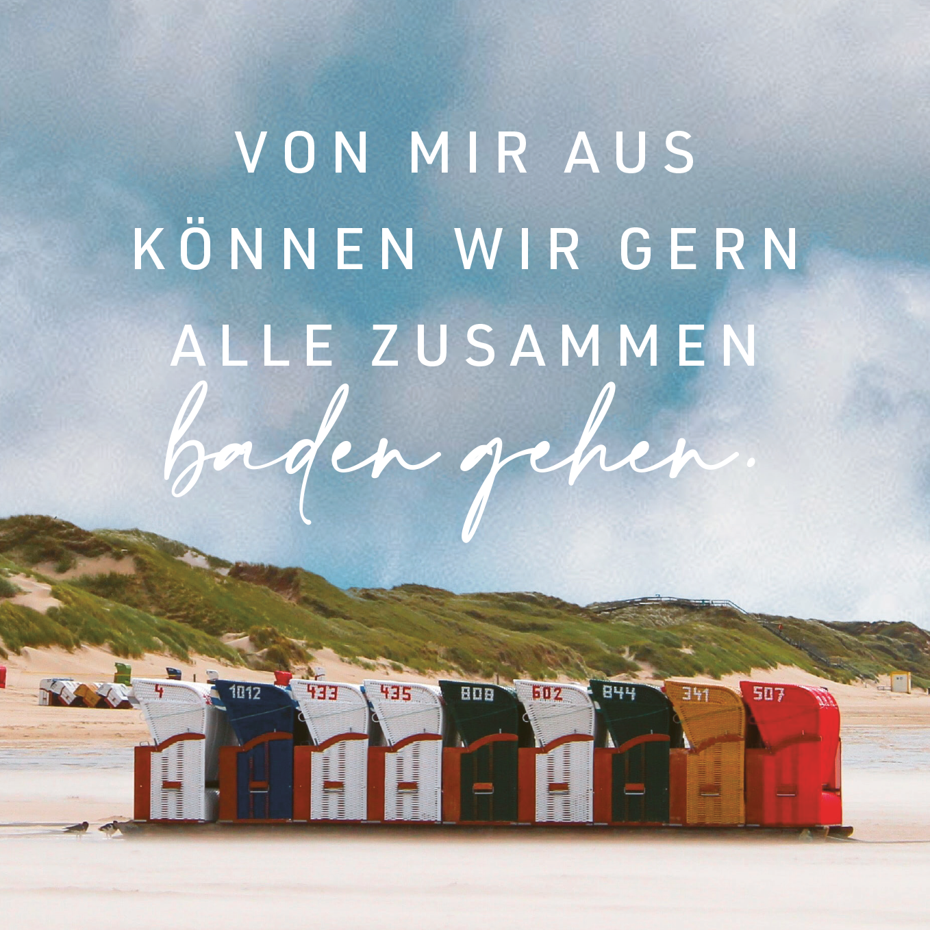 Gezeigt wird eine Innen- oder Zusatzansicht von „Kein Meer ist auch keine Lösung“. Auf dieser Abbildung sind mehrere farbige Strandkörbe in einer Reihe zu sehen, die in Rot- und Grüntönen gehalten sind. Der Hintergrund zeigt einen bewölkten Himmel sowie Dünenlandschaften. Über den Körben schwebt der handschriftliche Schriftzug „Von mir aus können wir gern alle zusammen baden gehen“ in großer, weißer Schrift, die einladend und freundlich wirkt.