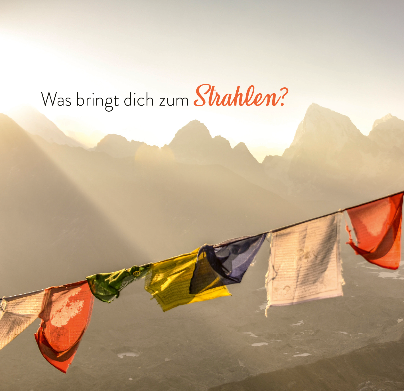 Gezeigt wird eine Innen- oder Zusatzansicht von „365 Inspirationen, achtsam zu leben“. Die Abbildung zeigt bunte Gebetsfahnen, die sanft im Wind flattern, vor einer lichtdurchfluteten Berglandschaft. Der Hintergrund ist in sanften, warmen Farben gehalten, während der Text „Was bringt dich zum Strahlen?“ in einer eleganten, orangefarbenen Schriftart platziert ist, die eine einladende Atmosphäre schafft.