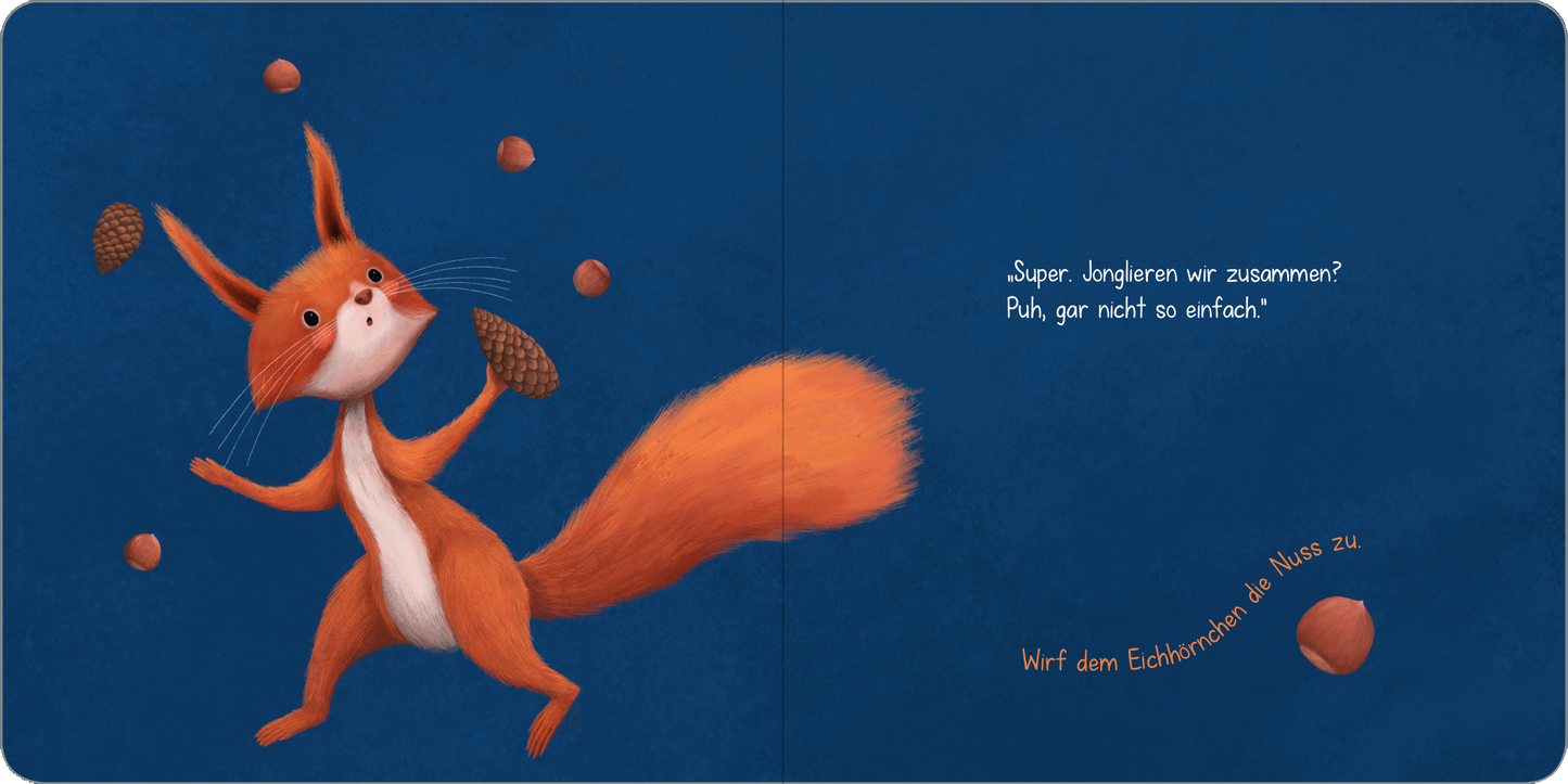 Gezeigt wird eine Innen- oder Zusatzansicht von „Ein kleines Geheimnis – Spiel mit mir und ich verrat es dir!“. Das Bild zeigt einen lebhaften, orangefarbenen Fuchs, der mit einem fröhlichen Gesichtsausdruck drei Eicheln jongliert. Der Hintergrund ist in einem tiefen Blau gehalten, das die Szene hervorhebt. Links steht in heller, spielerischer Schrift der Satz: „Super, jonglieren wir zusammen? Puh, gar nicht so einfach!“. Rechts befindet sich der Aufruf „Wirf dem Eichhörnchen die...