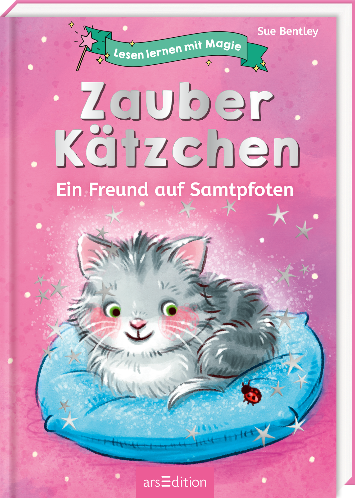 Auf dem Buchcover „Zauber Kätzchen – Ein Freund auf Samtpfoten“ von Sue Bentley ist ein niedliches, graues Kätzchen auf einem blauen Kissen zu sehen. Der Hintergrund ist in einem sanften Pinkton gehalten, mit glitzernden Sternen, die eine magische Atmosphäre erzeugen. Die Titeltypografie ist verspielt und freundlich gestaltet, wobei „Zauber Kätzchen“ in großen, weißen Buchstaben hervorsticht. Oben links befindet sich eine Bannergrafik mit dem Schriftzug „Lesen lernen mit...