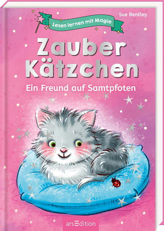 Auf dem Buchcover „Zauber Kätzchen – Ein Freund auf Samtpfoten“ von Sue Bentley ist ein niedliches, graues Kätzchen auf einem blauen Kissen zu sehen. Der Hintergrund ist in einem sanften Pinkton gehalten, mit glitzernden Sternen, die eine magische Atmosphäre erzeugen. Die Titeltypografie ist verspielt und freundlich gestaltet, wobei „Zauber Kätzchen“ in großen, weißen Buchstaben hervorsticht. Oben links befindet sich eine Bannergrafik mit dem Schriftzug „Lesen lernen mit...