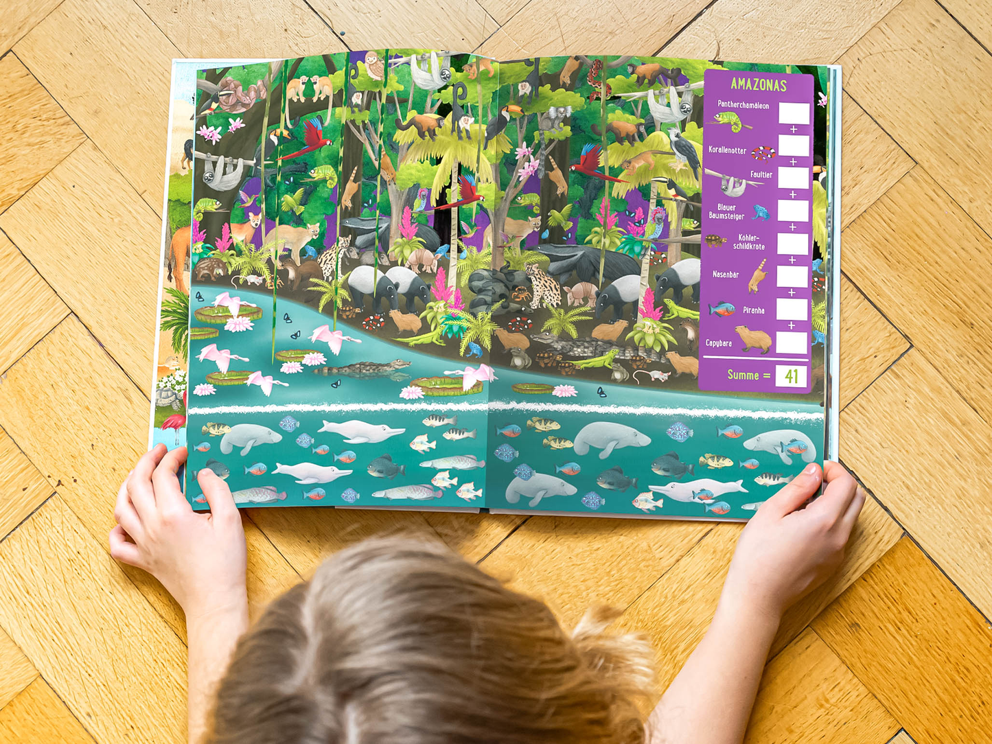 Gezeigt wird eine Innenansicht von „Die große Tierzählerei“. Gezeigt wird ein Kind von oben, das gerade das buch betrachtet und eines der Dschungel-Seiten aufgeschlagen hat. Man kann den Hinterkopf des Kindes und seine Arme sehen, welche das Buch vorsichtig halten. Das Buch und das Kind liegen auf einem Holzboden.