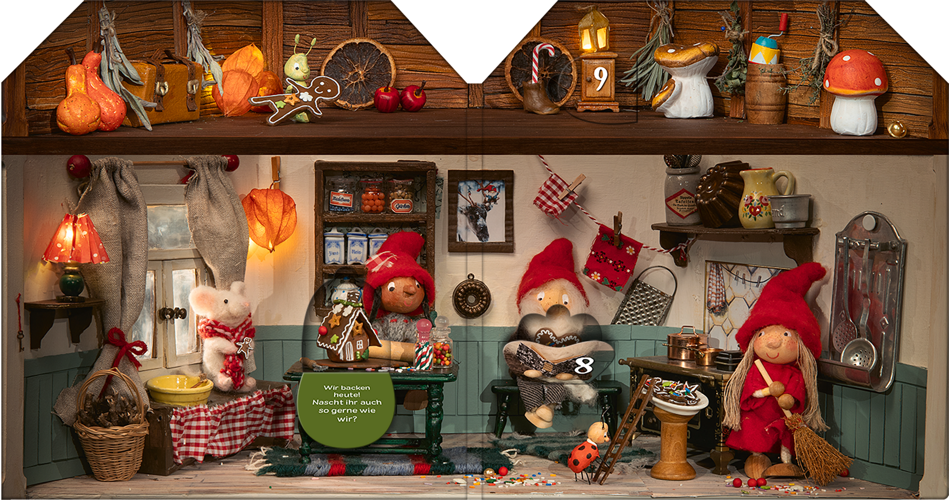 Gezeigt wird eine Innen- oder Zusatzansicht von „Advent im Wichtelhaus“. Die Szene zeigt eine weihnachtlich dekorierte Wichtelhütte mit verschiedenen Figuren in roten Mützen. Auf dem Tisch stehen bunte Bastelmaterialien und ein zubereiteter Plätzchenteller. An den Wänden hängen Lichter und Küchengeräte in warmen Erdtönen. Die Typografie der sichtbaren Texte ist verspielt und gut lesbar, unterstrichen durch einige traditionell weihnachtliche Elemente wie Lebkuchen und Dekorationen.