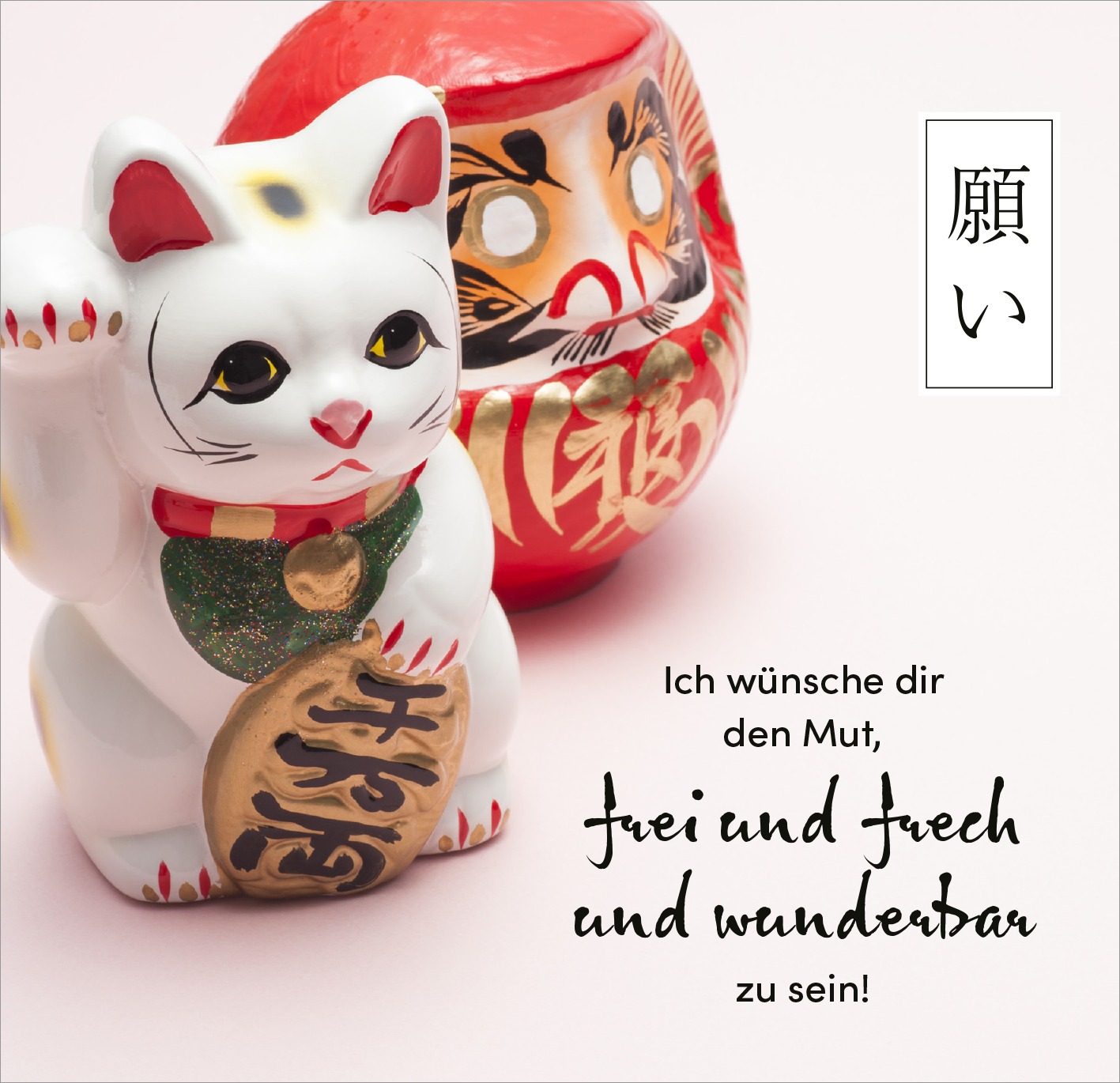 Gezeigt wird eine Innen- oder Zusatzansicht von „Sei gut zu dir“. Die Darstellung zeigt eine weiße Glücksfigur in Form einer Katze mit einer grünen Halskette und einer goldenen Münze. Im Hintergrund ist ein roter Glücksbringer mit einem künstlerischen Gesichtsmotiv zu sehen. Der Text „Ich wünsche dir den Mut, frei und frech und wunderbar zu sein!“ ist in einer dynamischen, handschriftlichen Schriftart in Schwarz gehalten, während ein japanisches Zeichen rechts oben platziert ist.