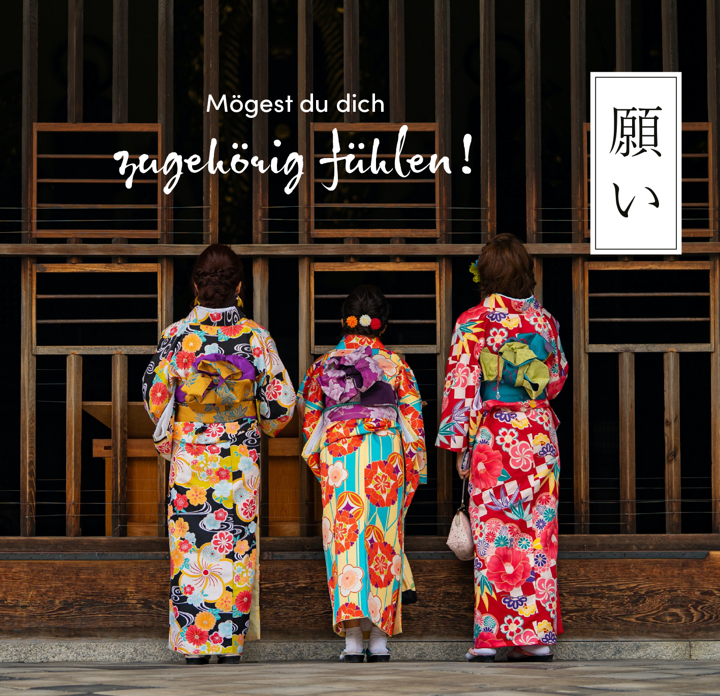 Gezeigt wird eine Innen- oder Zusatzansicht von „Sei gut zu dir“. Die Szene zeigt drei Frauen in farbenfrohen Kimonos, die lebendige Blumenmuster und kräftige Farben wie Rot, Blau und Gelb aufweisen. Sie stehen Rücken an Rücken und blicken in eine Art Innenraum. Über ihnen schwebt der Schriftzug „Mögest du dich zugehörig fühlen!“ in einer verspielten Schriftart, während auf der rechten Seite ein minimalistisches, japanisches Schriftzeichen in einem weißen Kasten zu sehen ist.