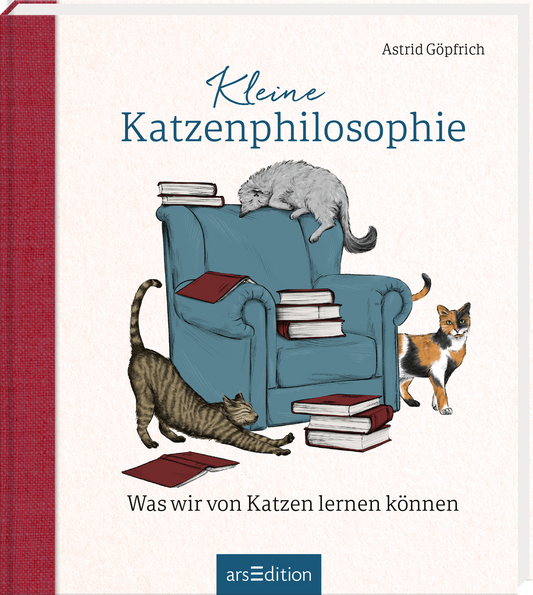 Das Buchcover zeigt einen gemütlichen blauen Sessel, auf dem drei stilisierte Katzen spielen und dösen. Die Farbtöne sind überwiegend sanft und hell, mit dominierendem Blau für den Sessel und lebendigen Farben für die Katzen. Der Titel „Kleine Katzenphilosophie“ ist in verspielter, blauer Schrift platziert, während der Untertitel „Was wir von Katzen lernen können“ in einer schlichten, grauen Font darunter steht. Oben rechts ist der Name der Autorin, Astrid Göpfrich, zu sehen....
