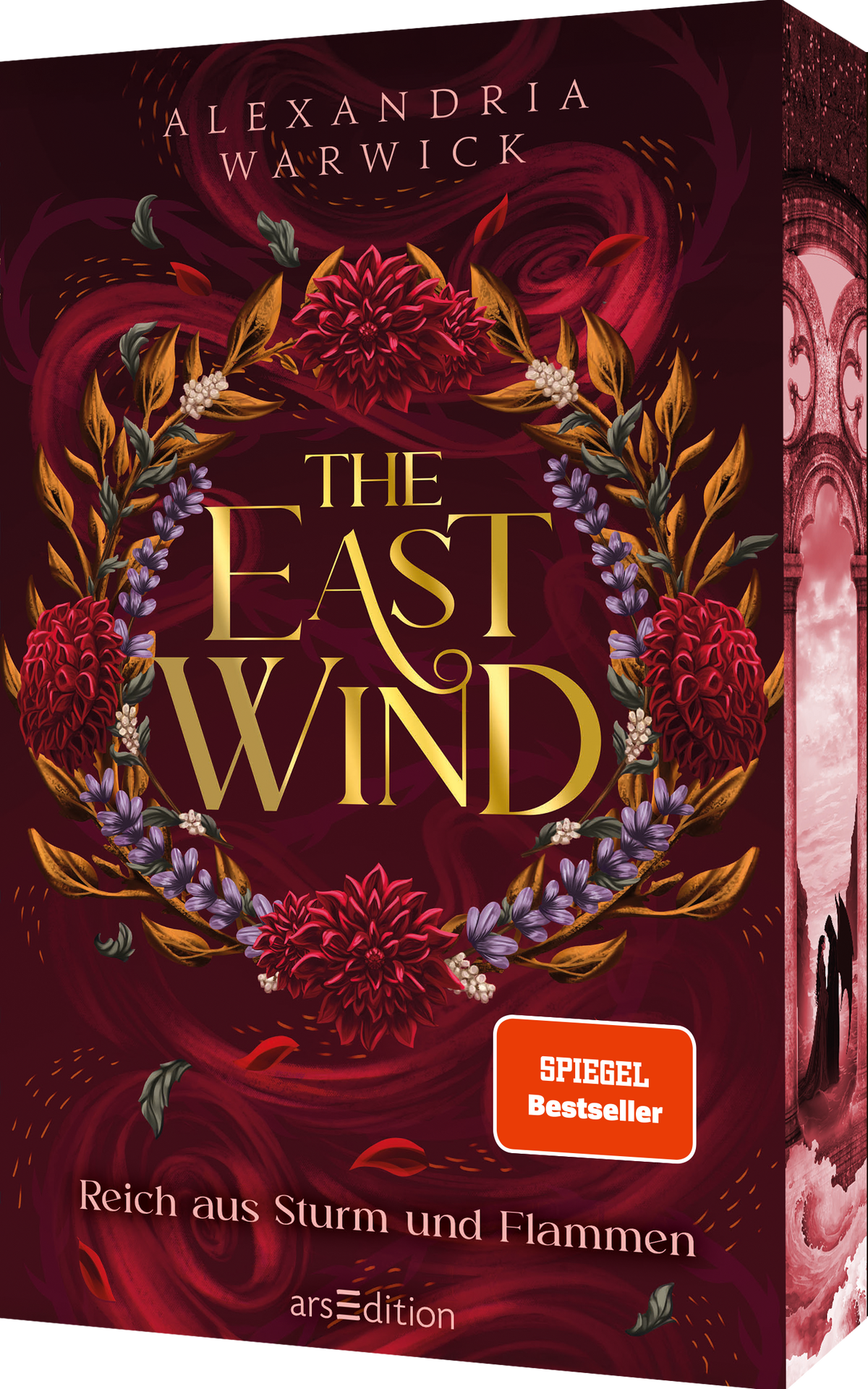 Das Cover ist dunkelrot und zeigt zentral einen opulenten Kranz aus roten und lila Blüten sowie goldenen Blättern. Mittig steht der Titel „THE EAST WIND“ in goldenen Buchstaben, darüber der Name der Autorin Alexandria Warwick. Der Untertitel „Reich aus Sturm und Flammen“ steht am unteren Rand in kleinerer Schrift. Unten rechts befindet sich ein orangefarbener Button mit dem Text „SPIEGEL Bestseller“. Ganz unten mittig steht der Logoschriftzug von arsEdition.