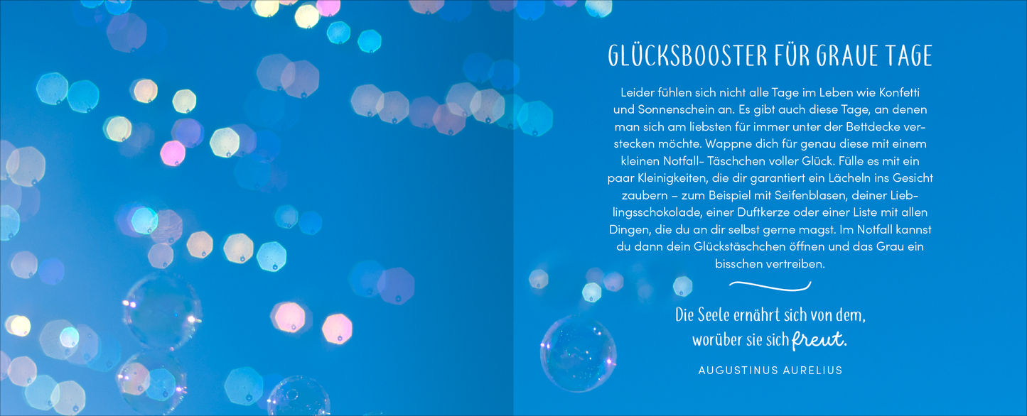 Gezeigt wird eine Innen- oder Zusatzansicht von „Kopf hoch – Alles wird wieder gut“. Der Hintergrund ist in einem sanften Blau gehalten, das an einen klaren Himmel erinnert. Auf der linken Seite sind mehrfarbige, unscharfe Lichtkugeln zu sehen, die eine fröhliche und entspannte Atmosphäre schaffen. Rechts befindet sich eine helle, harmonische Schrift, die den Titel „GLÜCKSBOOSTER FÜR Graue TAGE“ und einen einladenden Text präsentiert. Die Typografie ist gut lesbar und vermittelt...