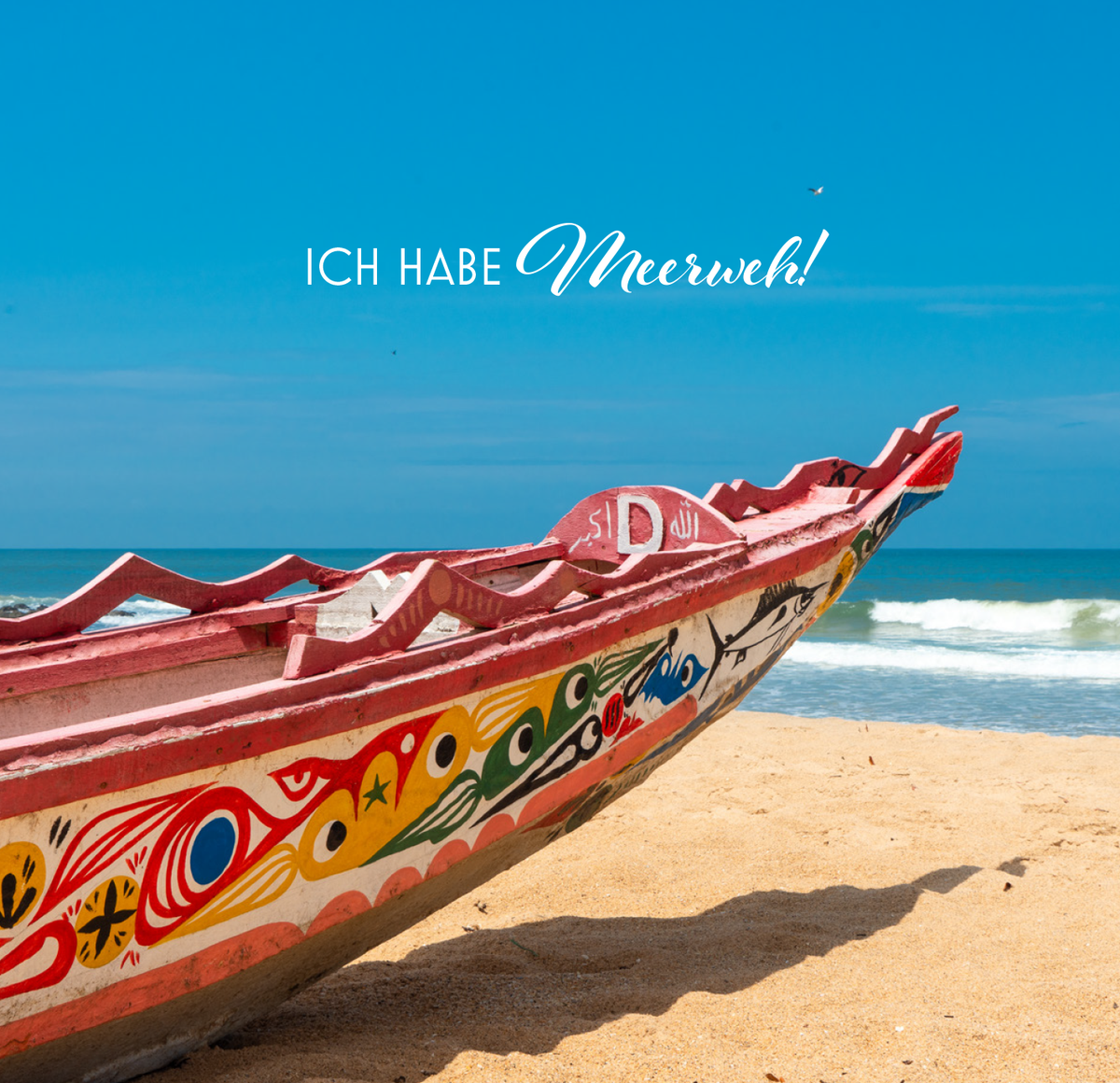 Gezeigt wird eine Innen- oder Zusatzansicht von „Mehr Meer, bitte!“. Das Bild zeigt ein kunstvoll verziertes Boot am Strand, umgeben von sanften Wellen und einem strahlend blauen Himmel. In verspielter, eleganter Schrift ist der Schriftzug „ICH HABE Meerweh!“ platziert. Die Farben der Bootdekoration sind lebhaft und vielfältig, mit exotischen Mustern in Rot, Gelb, Grün und Blau, die die maritime Stimmung unterstreichen.