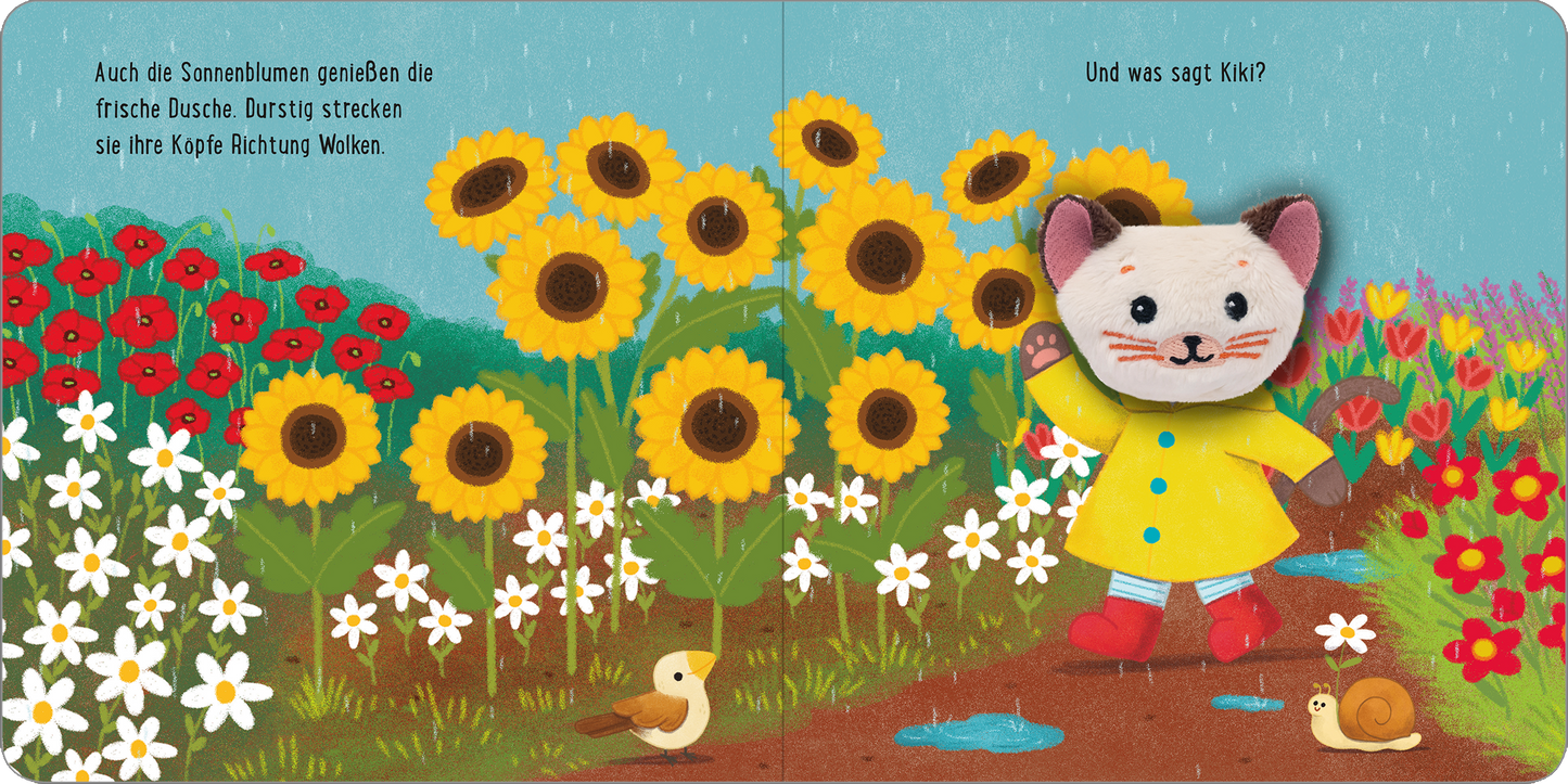 Gezeigt wird eine Innen- oder Zusatzansicht von „Meine sprechende Fingerpuppe: Was sagt die Katze?“. Die Illustration zeigt eine freundliche Katze in einem gelben Regenmantel, umgeben von bunten Sonnenblumen mit leuchtend gelben Köpfen und grünen Blättern. Der Hintergrund ist in sanften Blau- und Grüntönen gehalten, während klitzekleine Vögel und eine Schnecke das Bild ergänzen. Die Schrift ist verspielt und farbenfroh und hebt die Frage „Und was sagt Kiki?“ deutlich hervor.