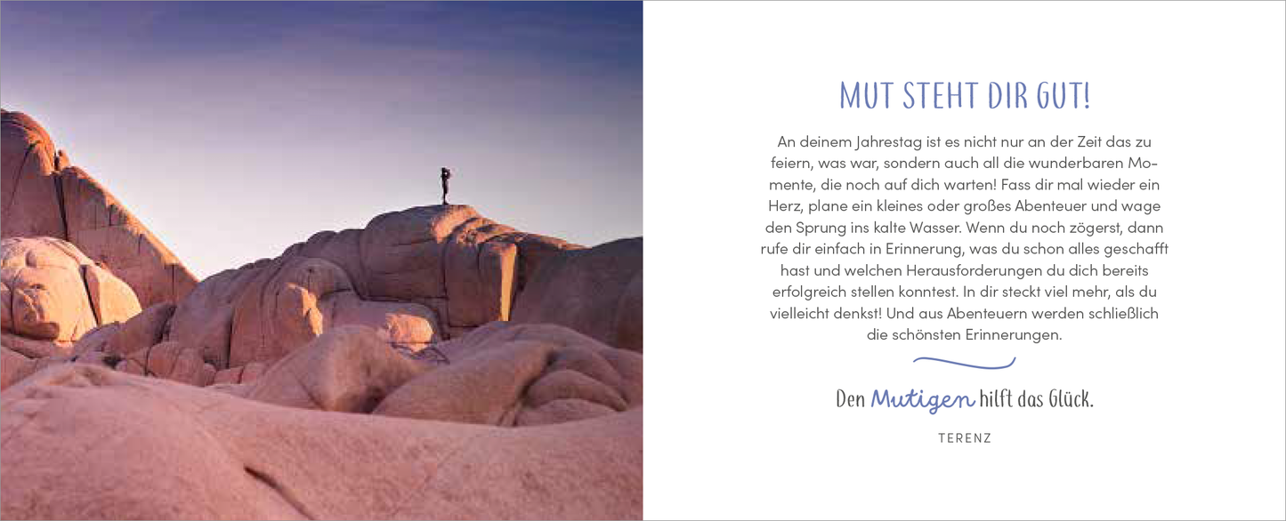 Gezeigt wird eine Innen- oder Zusatzansicht von „Alles Liebe zum Jahrestag“. Die linke Seite zeigt eine sanfte, rosa-farbenen Felsküste unter einem leicht lila gefärbten Himmel, mit einer Person, die auf einem Felsen steht. Die rechte Seite enthält den Schriftzug „Mut steht dir gut!“ in einer eleganten blauen Schrift. Darunter beginnt der Text mit einer freundlichen Einladung, den Jahrestag aktiv zu feiern, gefolgt von einer Abschlusszeile in geschwungener Schrift.