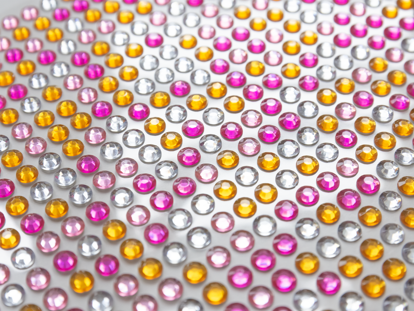 Gezeigt wird eine Innen- oder Zusatzansicht von „I Love to Sparkle – Flower-Power“. Die Ansicht zeigt ein Muster aus multicolorierten, glänzenden Schmucksteinen in Rosa, Gelb und Silber, die gleichmäßig auf einer hellen Oberfläche angeordnet sind. Die Farben sind lebhaft und strahlen Fröhlichkeit aus. Die Typografie ist verspielt und integriert sich harmonisch in das florale Design, was den funkelnden Charakter des Produkts unterstreicht.