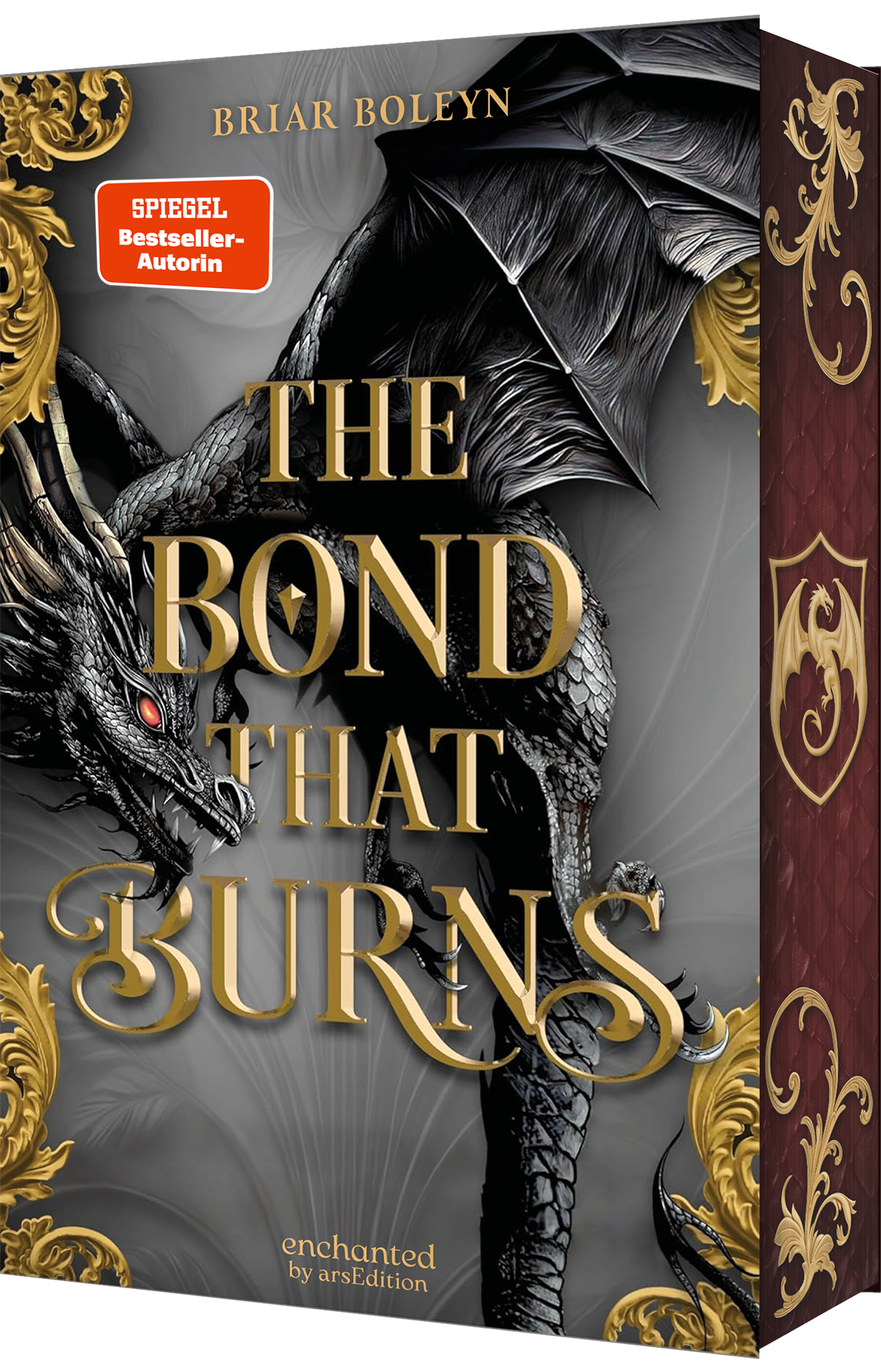 Das Buchcover zeigt einen majestätischen Drachen in Schwarz und Grau, dessen schimmernde Schuppen und eindringlicher Blick die Fantasiewelt einfangen. In goldener, geschwungener Schrift steht „THE BOND THAT BURNS“ prominent im Zentrum. Oben links befindet sich ein roter Button mit der Aufschrift „SPIEGEL Bestseller-Autorin“. Der Hintergrund wird von filigranen goldenen Verzierungen umrahmt, die eine mystische Atmosphäre erzeugen. Ganz unten mittig steht der Logoschriftzug von...