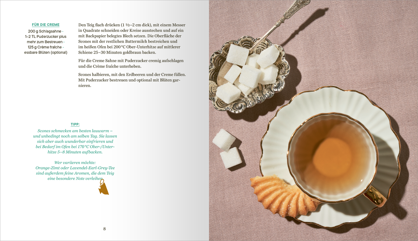 Gezeigt wird eine Innenansicht von „More than a Cup of Tea“. Auf der Seite sind ein elegant dekorierter Kaffeeteller und eine Tasse mit Honigfarbenem Tee abgebildet. Neben der Tasse liegen einige Zuckerstücke in einer silbernen Schale sowie ein Buttergebäck. Der Hintergrund ist hell gestaltet, während die farbenfrohe Typografie auf der linken Seite wichtige Informationen bietet. Die Aufnahme vermittelt eine einladende, gemütliche Atmosphäre.