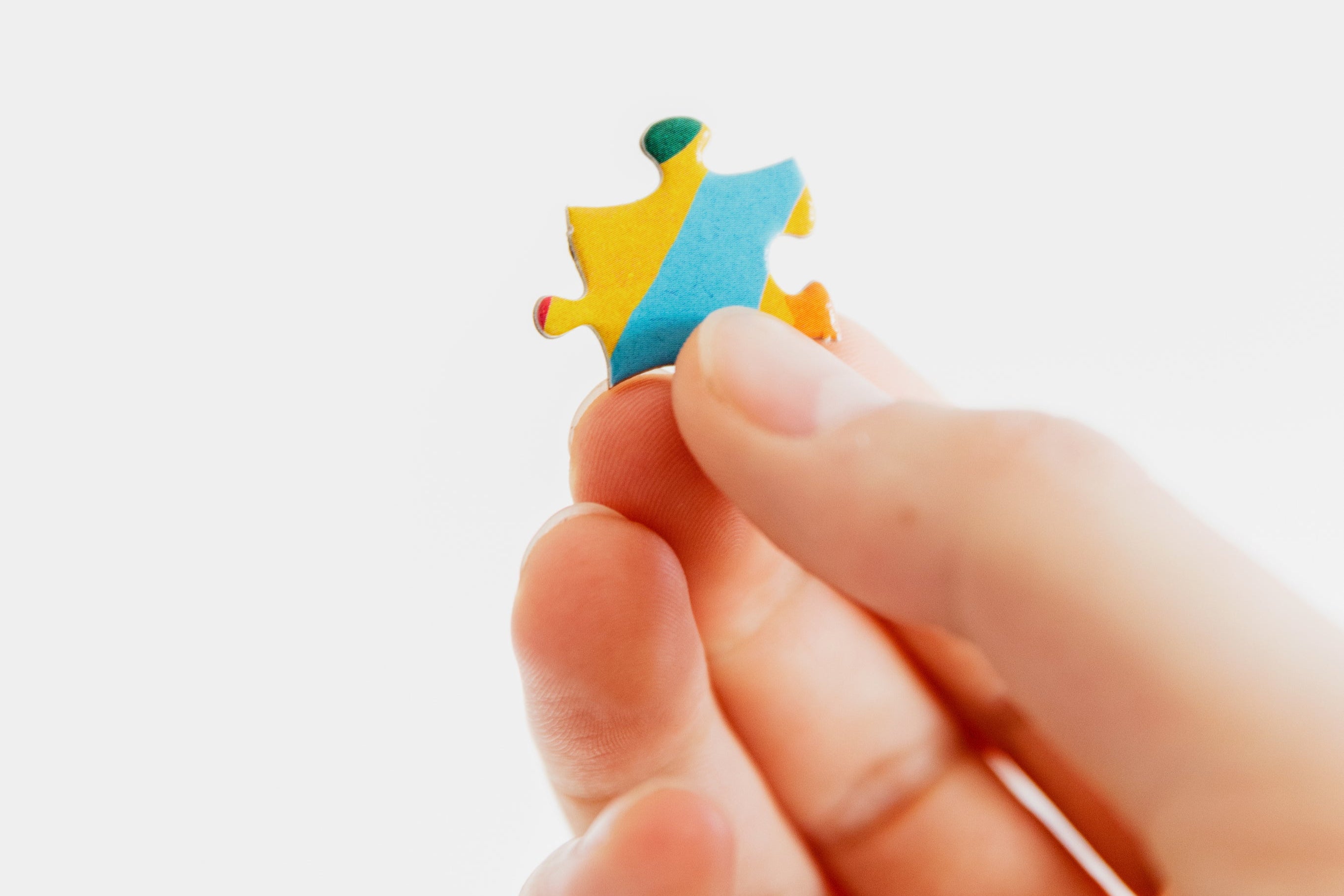 Foto einer Hand, die ein Puzzlestück hält