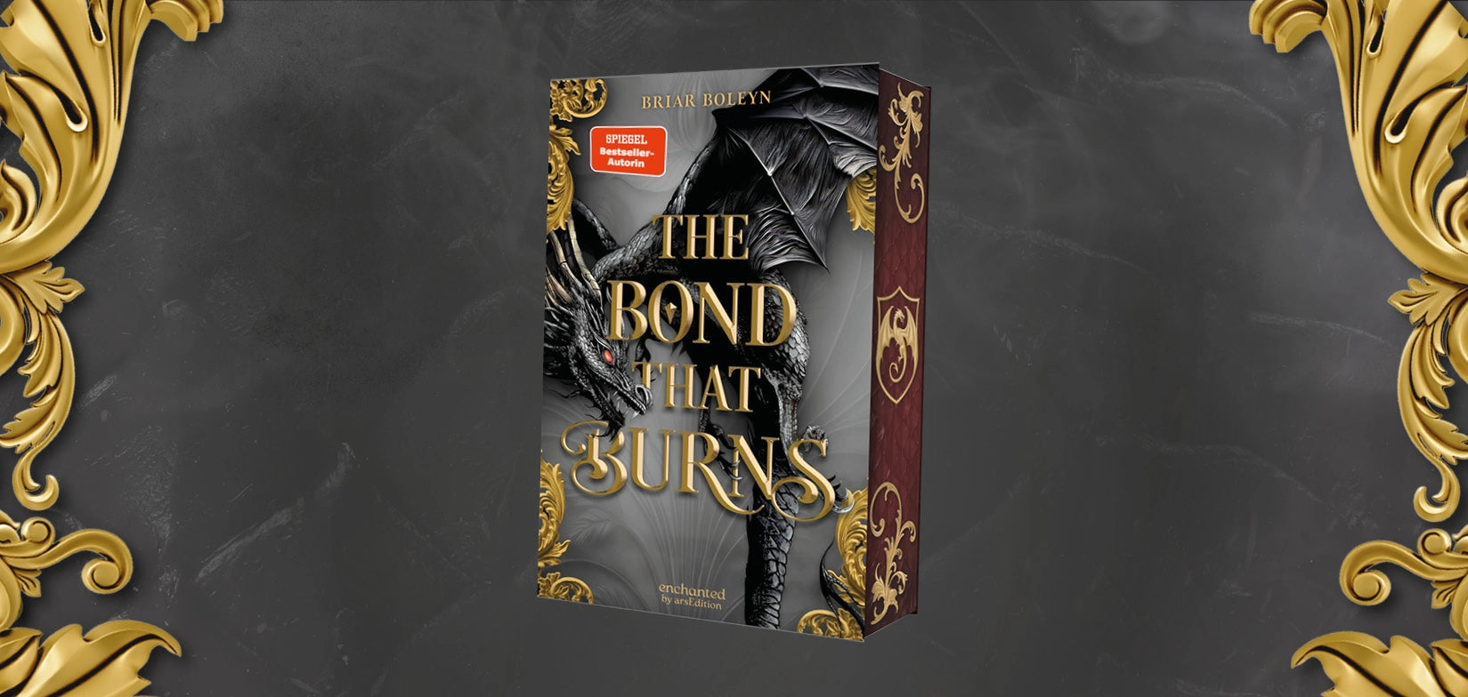 Buchcover „The Bond That Burns" von Briar Boleyn, erschienen bei enchanted by arsEdition. Das Cover zeigt einen imposanten schwarzen Drachen mit roten Augen vor einem dunkelgrauen Hintergrund. Der Titel ist in goldener, verschnörkelter Schrift gestaltet. Die Buchecken sind mit goldenen Ornamenten verziert. Der Buchrücken ist in Dunkelrot gehalten mit einem goldenen Drachenwappen. Ein roter Sticker kennzeichnet die Autorin als „SPIEGEL Bestseller-Autorin". Der Hintergrund des Banners ist dunkelgrau mit golde