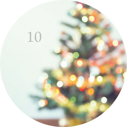Gezeigt wird eine Innen- oder Zusatzansicht von „Adventskalender in der Dose. 24 kleine Yoga-Auszeiten für den Advent“. Die Darstellung zeigt unscharfe Lichter eines Weihnachtsbaums in sanften, warmen Farben wie Gelb, Grün und Rot, die eine festliche Stimmung erzeugen. In der oberen linken Ecke ist die Zahl „10“ in einem schlichten, grauen Font zu sehen, was auf das entsprechende Türchen des Adventskalenders hinweist. Der Hintergrund ist hell gehalten.