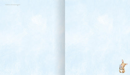 Gezeigt wird eine Innenansicht von „Hurra, ich bin da!“. Die Doppelseite präsentiert einen sanften, hellblauen Hintergrund, der an einen klaren Himmel erinnert. In der rechten unteren Ecke ist ein niedliches, illustratives Kaninchen abgebildet, das freundlich in die Richtung des Betrachters schaut. Die Typografie ist verspielt gehalten und wirkt kindgerecht, während die weichen Farbtöne eine beruhigende und einladende Atmosphäre schaffen.