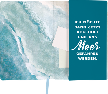 Gezeigt wird eine Innen- oder Zusatzansicht von „myNOTES Notizbuch A5: Warum wohnt das Meer nur so weit weg von mir?“. Die linke Innenseite zeigt eine sanfte aquamarinfarbene Wasserfarbe, die an das Meer erinnert. Auf der rechten Seite ist ein dunkelblauer Bereich mit einem weißem, handschriftlich wirkenden Schriftzug: „ICH MÖCHTE DANN JETZT ABGEHOLT UND ANS Meer GEFAHREN WERDEN“. Der Text ist emotional und einladend gestaltet, was die Verbindung zum Thema des Notizbuchs verstärkt.