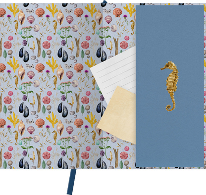 Gezeigt wird eine Innen- oder Zusatzansicht von „myNOTES Papeterie: Notizbuch A6 Naturschätze“. Die Innenseite zeigt ein farbenfrohes Muster mit maritimen Motiven, darunter Muscheln, Seesterne und Pflanzen in sanften Pastelltönen auf beigem Hintergrund. Das Notizbuch hat einen blauen Einband mit einer goldfarbenen Seepferdchen-Prägung, die einen eleganten Kontrast bildet. Einzelne Blätter mit linierter und unlinierter Fläche liegen sichtbar, um die Vielseitigkeit des Notizbuchs...