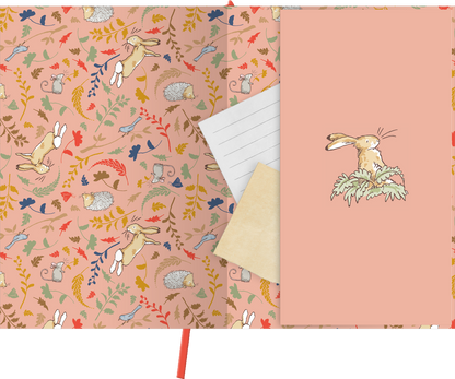Gezeigt wird eine Innen- oder Zusatzansicht von „myNOTES Papeterie: Weißt du eigentlich, wie lieb ich dich hab? Notizbuch A4“. Der Innenbereich präsentiert ein sanftes, rosafarbenes Muster, durchzogen von bunten, illustrativen Motiven von Tieren und Blättern. Auf der rechten Innenseite ist ein helles, strukturiertes Blatt mit einer feinen Linienführung sichtbar, während eine kleine Illustration eines Hasen in sanften Farben die Ecke ziert. Ein rotes Lesezeichen ergänzt das Design.