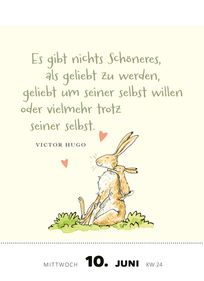 Gezeigt wird eine Innen- oder Zusatzansicht von „Abreißkalender Weißt du eigentlich, wie lieb ich dich hab? 2026“. Die Seite zeigt ein zartes, hellbeiges Hintergrunddesign mit einem niedlichen, gezeichneten Hasen, der aufrecht sitzt und einen anderen Hase umarmt. Der zentrale Text in einer verspielten, handschriftlichen Schriftart lautet: „Es gibt nichts Schöneres, als geliebt zu werden, geliebt um seiner selbst willen oder vielmehr trotz seiner selbst.“ Darunter steht der Autor...