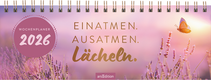 Auf dem Cover eines Wochenplaners für 2026 dominiert ein sanfter, pinker Farbverlauf im Hintergrund, durchzogen von lila Lavendelblüten. In der oberen Hälfte schwebt ein orangefarbener Schmetterling. Die Schriftzüge „EINATMEN. AUSATMEN. LÄCHELN.“ sind in eleganten, goldfarbenen Buchstaben gehalten. Oben links befindet sich ein runder Button mit dem Text „WOCHENPLANER 2026“. Ganz unten mittig steht der Logoschriftzug von arsEdition.