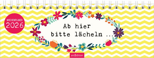Das Cover zeigt einen bunten Wochenplaner mit einem fröhlichen, gelben Wellenmuster im Hintergrund. In der Mitte umrahmt eine blumige Gestaltung den Text „Ab hier bitte lächeln …“, der in kräftiger, schwarzer Schrift geschrieben ist. Oben links befindet sich ein roter Button mit dem Text „WOCHENPLANER 2026“. Ganz unten mittig steht der Logoschriftzug von arsEdition.