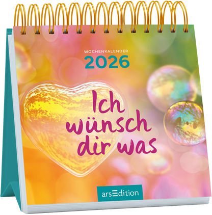 Der Kalender zeigt ein sanftes, farbenfrohes Hintergrundbild mit pastellfarbenen Blasen und einem warmen, herzförmigen Element in der Mitte. In verspielter, lila Schrift steht „Ich wünsch dir was“ prominente platziert. An der Oberseite ist „WOCHENKALENDER 2026“ in einem helleren Blauton zu sehen. Die Gesamtatmosphäre ist freundlich und einladend. Ganz unten mittig steht der Logoschriftzug von arsEdition.