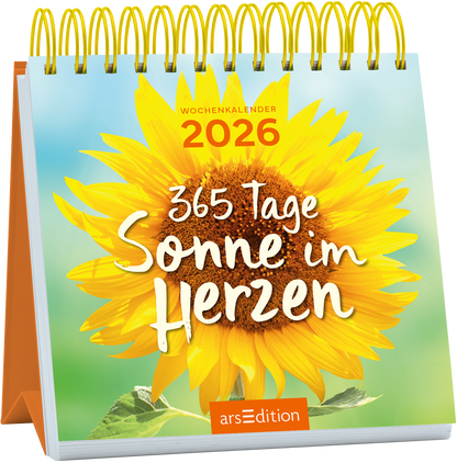 Das Cover zeigt eine strahlende Sonnenblume in leuchtenden Gelbtönen vor einem sanften, hellblauen Hintergrund. Der Titel „365 Tage Sonne im Herzen“ steht in verspielter, weißer Schrift, die fröhlich wirkt. Oben links ist der Text „WOCHENKALENDER 2026“ in schwarzen Buchstaben platziert. Ganz unten mittig steht der Logoschriftzug von arsEdition.