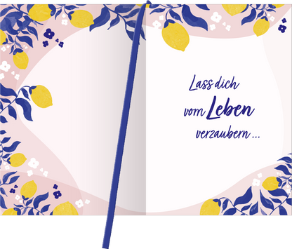 Gezeigt wird eine Innen- oder Zusatzansicht von „Buchkalender Heute ist mein Lieblingstag 2026“. Die Seite ist von zarten pastel Farben in Rosa und Gelb geprägt, mit floralen Mustern und Zitronenverzierungen. In der Mitte steht der Text „Lass dich vom Leben verzaubern …“ in einer eleganten, blauen Schriftart, die eine einladende und inspirierende Stimmung vermittelt. Der konzeptionelle Einsatz von Weißraum unterstützt die Lesbarkeit und Klarheit.