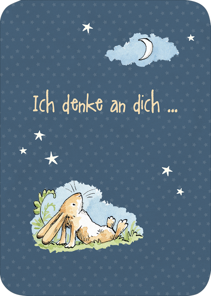 Gezeigt wird eine Innen- oder Zusatzansicht von „Weißt du eigentlich, wie lieb ich dich hab? Geburtstagskalender im Holzständer“. Die abgebildete Seite zeigt einen sanften dunkelblauen Hintergrund, bestückt mit kleinen weißen Sternen. Im Vordergrund liegt ein niedlicher Hase, der relaxed auf einer bunten Wiese sitzt und den Nachthimmel betrachtet. Über dem Hasen ist der Text „Ich denke an dich ...“ in einer verspielten, handschriftlichen Schriftart präsentiert. Die Farben sind...