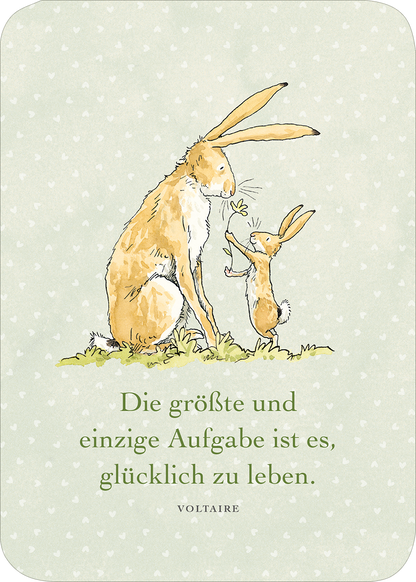 Gezeigt wird eine Innen- oder Zusatzansicht von „Weißt du eigentlich, wie lieb ich dich hab? Geburtstagskalender im Holzständer“. Die Illustration zeigt einen großen und einen kleinen Hasen, die auf einer grünen Wiese sitzen und miteinander interagieren. Der Hintergrund ist in einem sanften, pastellgrünen Farbton mit kleinen, weißen Herzchen gestaltet. Der Schriftzug „Die größte und einzige Aufgabe ist es, glücklich zu leben.“ ist in einer klaren, eleganten Typografie in...