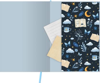 Gezeigt wird eine Innen- oder Zusatzansicht von „myNOTES Papeterie: Notizbuch A4 Book Nook“. Der innere Umschlag ist in einem sanften Blau gehalten und zeigt ein verspieltes, dunkles Muster mit Illustrationen von Büchern, Tassen, Blumen, Schmetterlingen und Himmelskörpern. Die Farben sind überwiegend in Blau-, Gelb- und Cremetönen gehalten, die symmetrisch angeordnet sind.