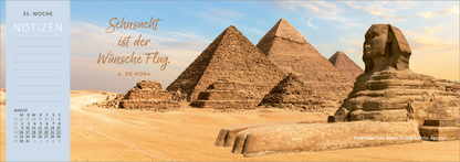 Gezeigt wird eine Innen- oder Zusatzansicht von „Tischkalender Reiseträume 2027“. Die Illustration zeigt eine beeindruckende Landschaft mit den Pyramiden von Gizeh und der Sphinx im Vordergrund, umgeben von Wüstensand. Darüber steht in eleganter, geschwungener Schriftzug „Sehnsucht ist der Wünsche Flug“ von A. de Noira. Der Hintergrund ist in warmen Erdtönen gehalten, während der Notizbereich links in einem sanften Blau mit klarer, gut lesbarer Typografie gestaltet ist.