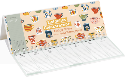 Gezeigt wird eine Innen- oder Zusatzansicht von „Tischkalender Heute ist mein Lieblingstag! 2027“. Die Ansicht zeigt eine offene Kalenderseite mit bunten Kaffeetassen auf einem hellen Hintergrund. Oben befindet sich der Schriftzug „Einfaches Glücksrezept!“ in auffälligem Gelb, darunter der Spruch „Weniger Stress, mehr Kaffeepausen!“ in sanften Farben. Die Wochentage sind in klarer, gut lesbarer Typografie dargestellt, mit ausreichend Platz für Notizen.