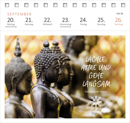 Gezeigt wird eine Innen- oder Zusatzansicht von „Postkartenkalender Yogaglück für jeden Tag 2027“. Im oberen Bereich des Kalenders befinden sich die Wochentage in einer klaren, modernen Schriftart, die in sanften Rottönen gehalten ist. Die zentrale Illustration zeigt eine Gruppe von stilisierten Buddha-Statuen vor einem goldenen Hintergrund, was eine ruhige und meditative Atmosphäre vermittelt. Am unteren Rand steht in verspielter Schrift: „Lächle, atme und gehe langsam.“ Der Name...