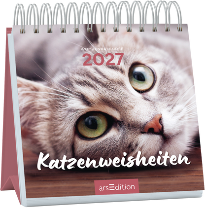 Auf dem Cover des Wochenkalenders „Katzenweisheiten“ 2027 ist eine ansprechende Nahaufnahme einer grauen Katze mit großen, ausdrucksvollen Augen zu sehen. Der Hintergrund ist sanft verschwommen und sorgt für eine harmonische Atmosphäre. Der Titel „Katzenweisheiten“ ist in einer freundlichen, weißen Schriftart platziert und verleiht dem Cover einen einladenden Charakter. Oben steht in dezentem Rot „WOCHENKALENDER 2027“. Ganz unten mittig steht der Logoschriftzug von arsEdition.