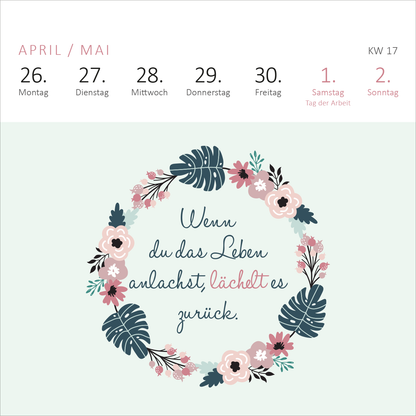 Gezeigt wird eine Innen- oder Zusatzansicht von „Mini-Wochenkalender Sei frech, wild und wunderbar! 2027“. Der Hintergrund ist in einem sanften Mintgrün gehalten, während die oberste Reihe die Tage der Woche in hellen, klaren Schriftzügen anzeigt. Im Zentrum ziert ein florales Kranzdesign die Seite, umrahmt von stilisierten Blättern und bunten Blumen in Rosa, Blau und Grün. Der Spruch „Wenn du das Leben anlachst, lächelt es zurück“ ist in eleganter, geschwungener Schriftart...