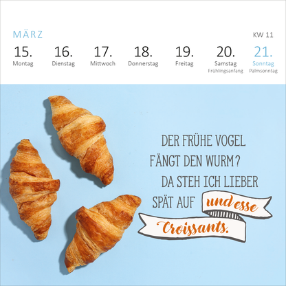 Gezeigt wird eine Innen- oder Zusatzansicht von „Mini-Wochenkalender Bevor ich mich jetzt aufrege, ist es mir lieber egal! 2027“. Die Darstellung zeigt einen hellblauen Hintergrund mit drei goldbraun gerösteten Croissants. Rechts daneben steht der humorvolle Text „DER FRÜHE VOGEL FÄNGT DEN WURM? DA STEH ICH LIEBER SPÄT AUF und esse Croissants.“ Die Schrift ist in verschiedenen Stilen gehalten, wobei die hervorgehobenen Worte in einer handschriftlichen Schriftart erscheinen.