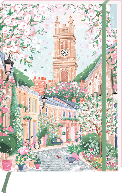 Das Buchcover zeigt eine malerische Straßenansicht mit blühenden Kirschbäumen und bunten Blumen in Töpfen. Im Hintergrund ragt ein hoher, historischer Turm mit einer großen Uhr in sanften Erdtönen empor. Die Straßen sind von charmanten Häusern gesäumt, in denen sich eine angenehme Frühlingsatmosphäre widerspiegelt. Der Titel ist in verspielter Schriftart in einem zarten Rosa gehalten. Ganz unten mittig steht der Logoschriftzug von arsEdition.