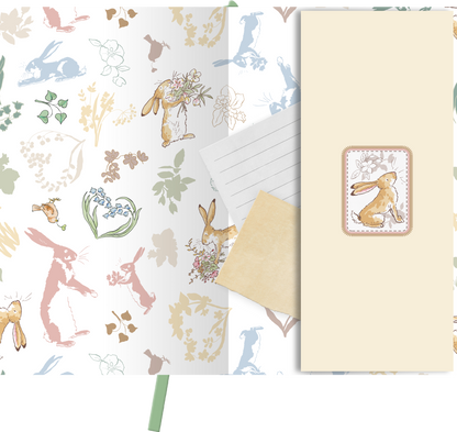 Gezeigt wird eine Innen- oder Zusatzansicht von „myNOTES Weißt du eigentlich, wie lieb ich dich hab? Notizbuch A6“. Die Ansicht zeigt eine sanfte, pastellige Farbauswahl mit floralen und tierischen Motiven, darunter Hasen und Blumen. Die Typografie ist verspielt und freundlich, ergänzt durch eine hellbeige Einschubtasche, die einen zarten Rahmen in einem floral gestalteten Etikett enthält. Die Designs vermitteln eine fröhliche und liebevolle Atmosphäre.