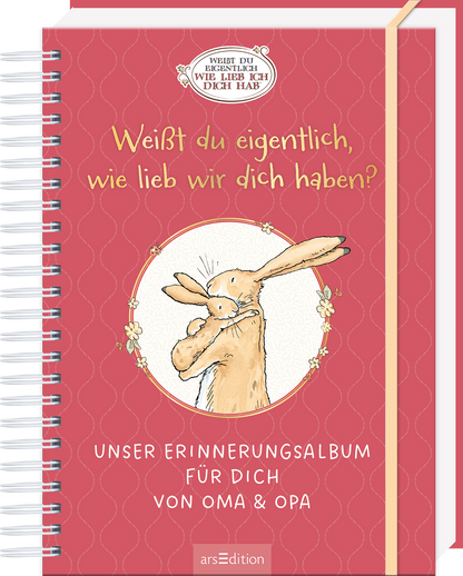 Das Buchcover zeigt einen roten, strukturierten Hintergrund mit einem spiralförmigen Rand. Im Zentrum befindet sich ein rundes, weißes Feld mit einer gezeichneten Hasenfigur, die einem Kind liebevoll ihre Umarmung signalisiert. Über dem Feld steht der Titel „Weißt du eigentlich, wie lieb wir dich haben?“ in großen, freundlichen Buchstaben. Unterhalb des Zentrums ist der Text „UNSER ERINNERUNGSALBUM FÜR DICH VON OMA &amp; OPA“ platziert. Ganz unten mittig steht der Logoschriftzug...
