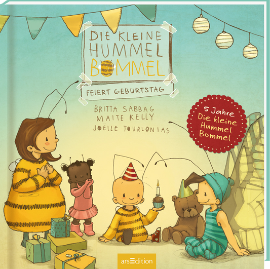 Das Buchcover zeigt eine fröhliche Geburtstagsszene mit vier Kindern, die in bunten, gestreiften und gepunkteten Outfits gekleidet sind. Im Hintergrund ist eine festliche Dekoration mit Girlanden und Papierlaternen in sanften Farben zu sehen. Der Titel „DIE KLEINE HUMMEL BOMMEL FEIERT GEBURTSTAG“ ist in großer, verspielter Schrift mittig platziert, während die Autoren Britta Sabbag, Maite Kelly und Joëlle Tourlonias darunter aufgeführt sind. Ein roter Button mit dem Text „5 Jahre Die...