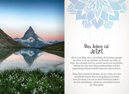 Gezeigt wird eine Innen- oder Zusatzansicht von „Achtsamkeit für dich“. Auf der linken Seite sieht man eine atemberaubende Berglandschaft mit dem Matterhorn, reflektiert im ruhigen Wasser eines Sees, umgeben von grünen Wiesen und blühenden Pflanzen. Die rechte Seite enthält den Text „Das Leben ist Jetzt“ in einer klaren, modernen Schriftart. Der Hintergrund ist in sanften, neutralen Farbtönen gehalten, ergänzt durch ein zartes, aquarellähnliches Muster einer Blüte in Blau, das...