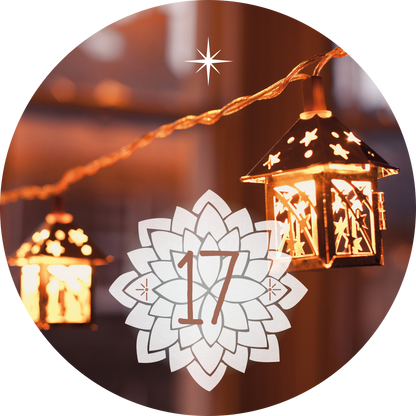 Gezeigt wird eine Innen- oder Zusatzansicht von „Adventskalender in der Dose. 24 Entspannungsmomente für den Advent“. Die Ansicht zeigt eine warme, stimmungsvolle Beleuchtung durch mehrere kleine Laternen, die goldene Lichtakzente setzen. Im Vordergrund befindet sich eine weiße, blattförmige grafische Gestaltung, die die Zahl „17“ in einer eleganten, braunen Schriftart zeigt. Der Hintergrund ist sanft verschwommen, was die festliche Atmosphäre unterstreicht.